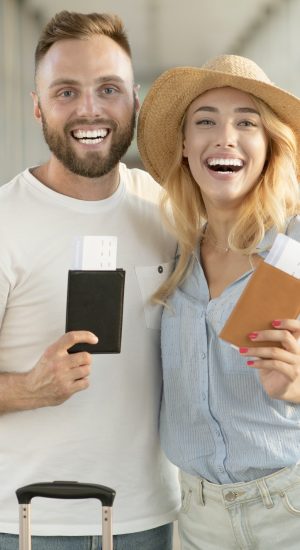 happy-couple-with-passports-and-tickets-at-airport-terminal.jpg